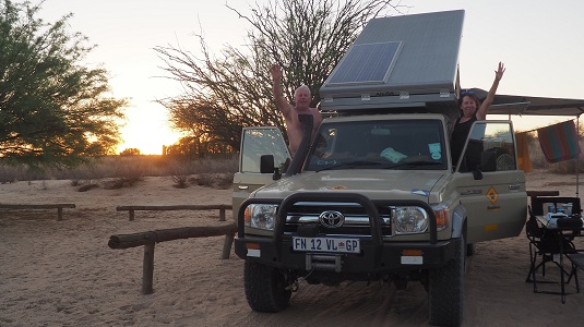 Photo de Msi et JP posant sur leur voiture Toyota Land Cruiser, à Nossob au KTP en Afrique du Sud lors, de notre  Road trip en Namibie 2017. 